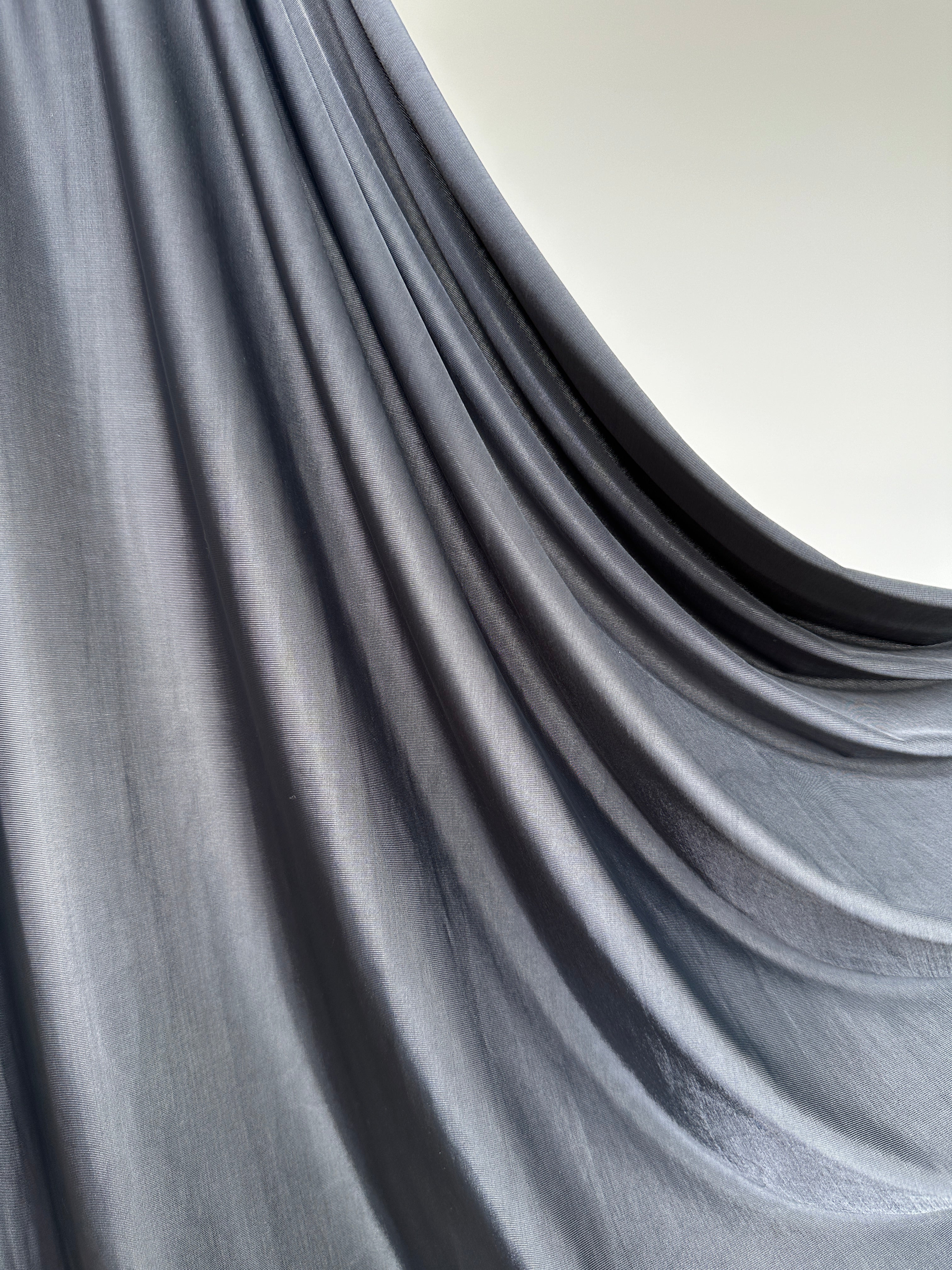 Détail du jersey liquide gris foncé, aspect lisse et légèrement satiné.