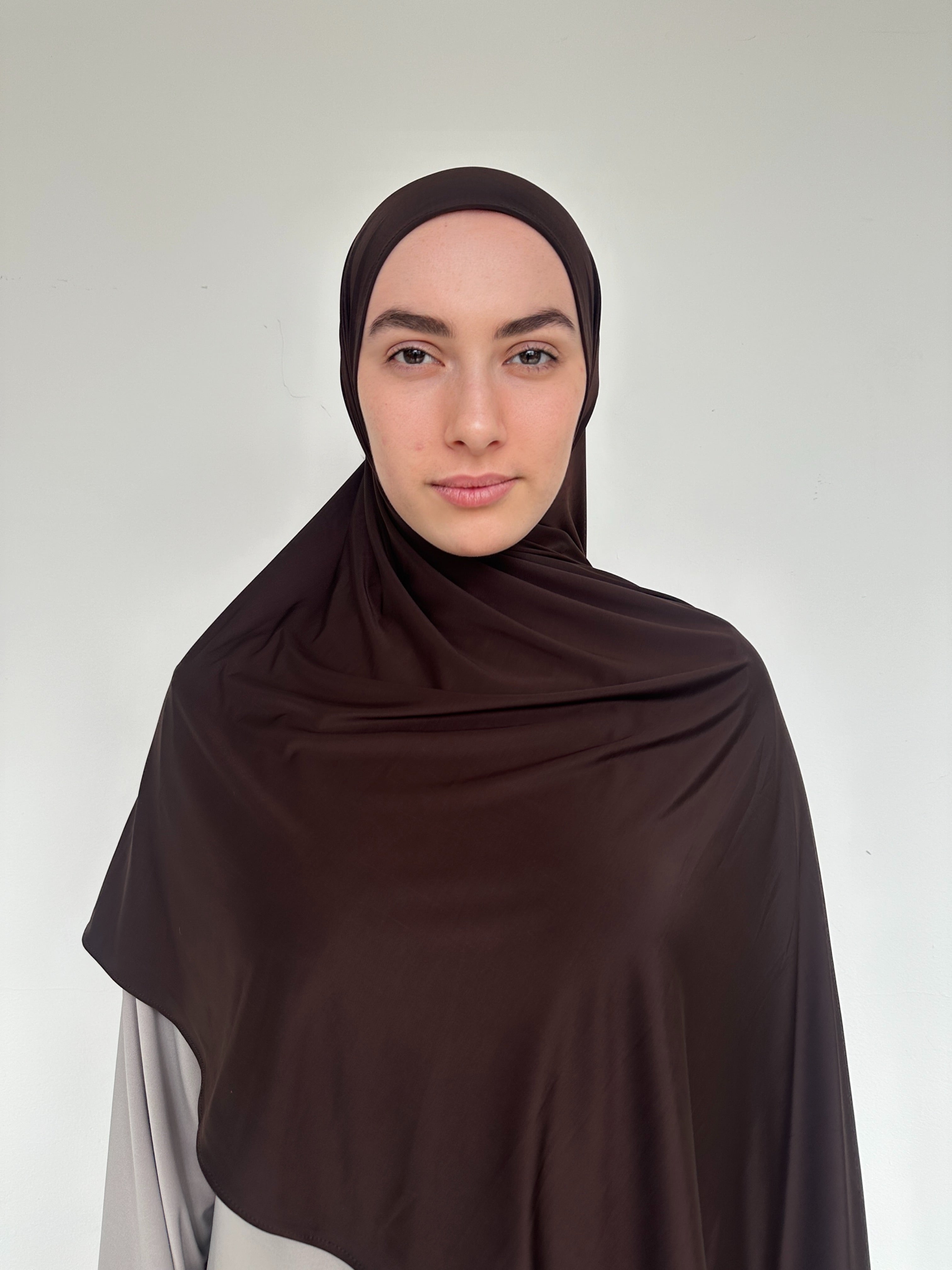 Hijab premium chocolat en jersey fluide, maintien parfait toute la journée.