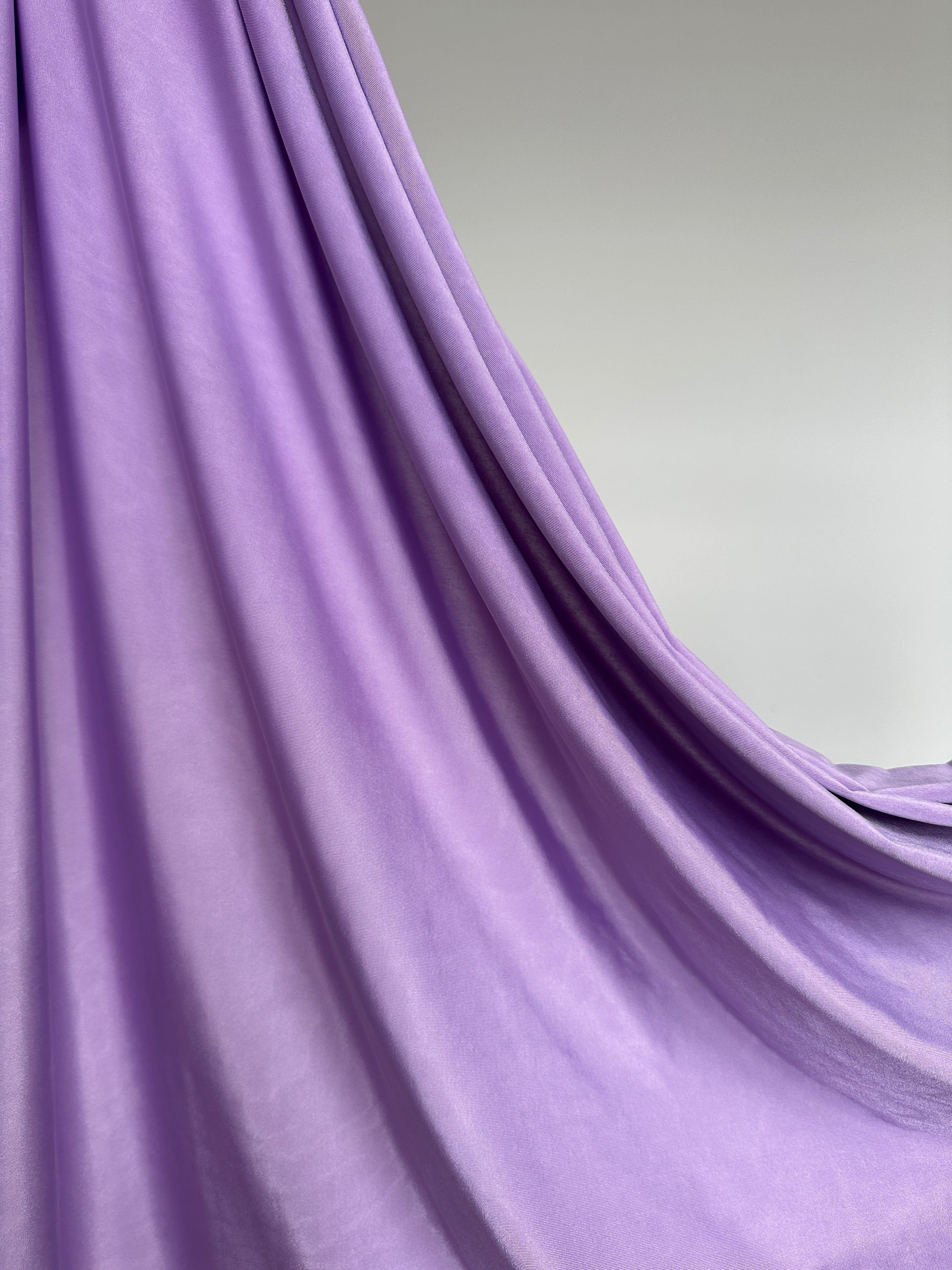 Détail du tissu jersey liquide lilas, texture fluide et extensible.