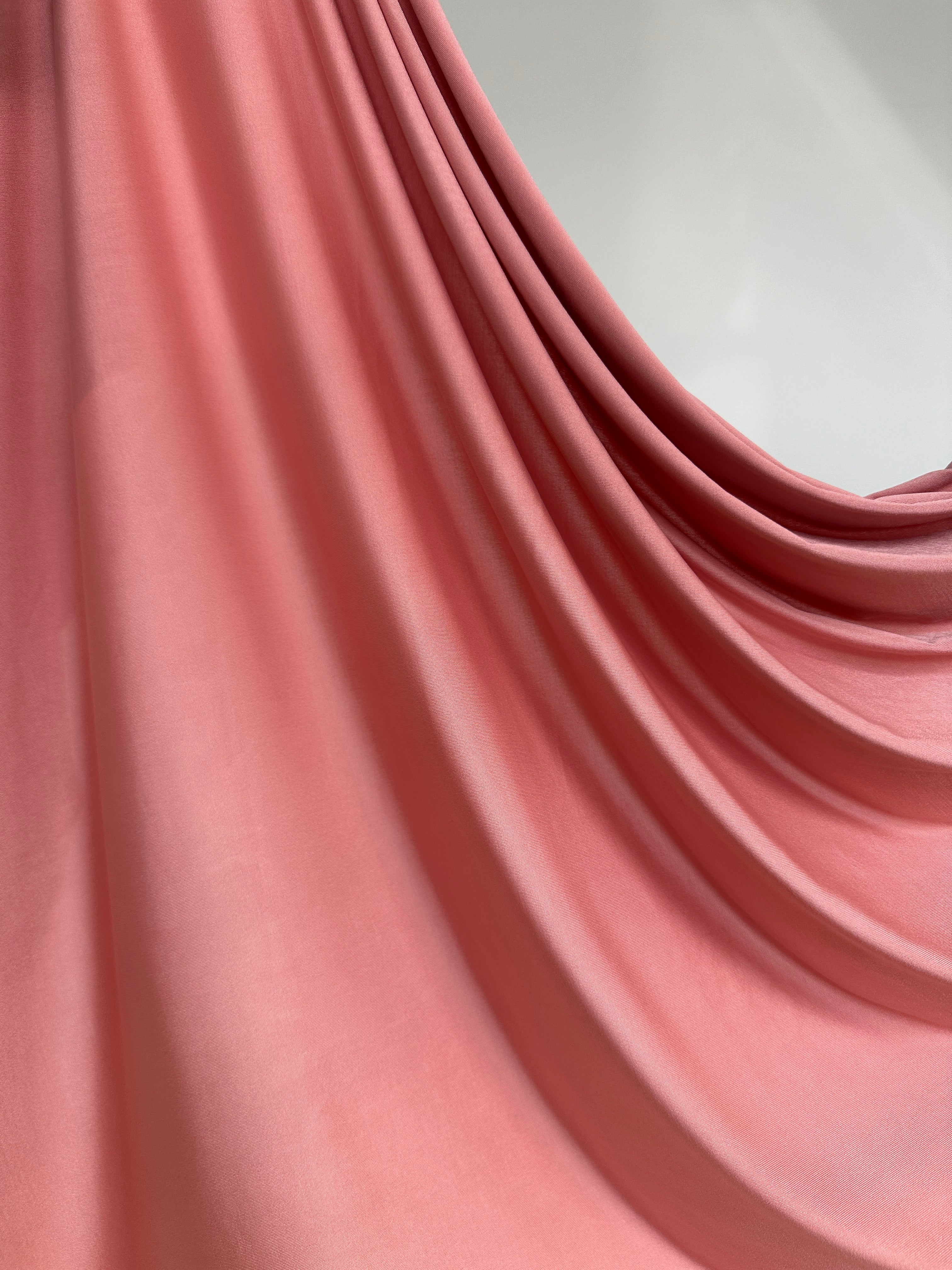 Détail de la couleur rose pêche poudré sur jersey liquide fluide.