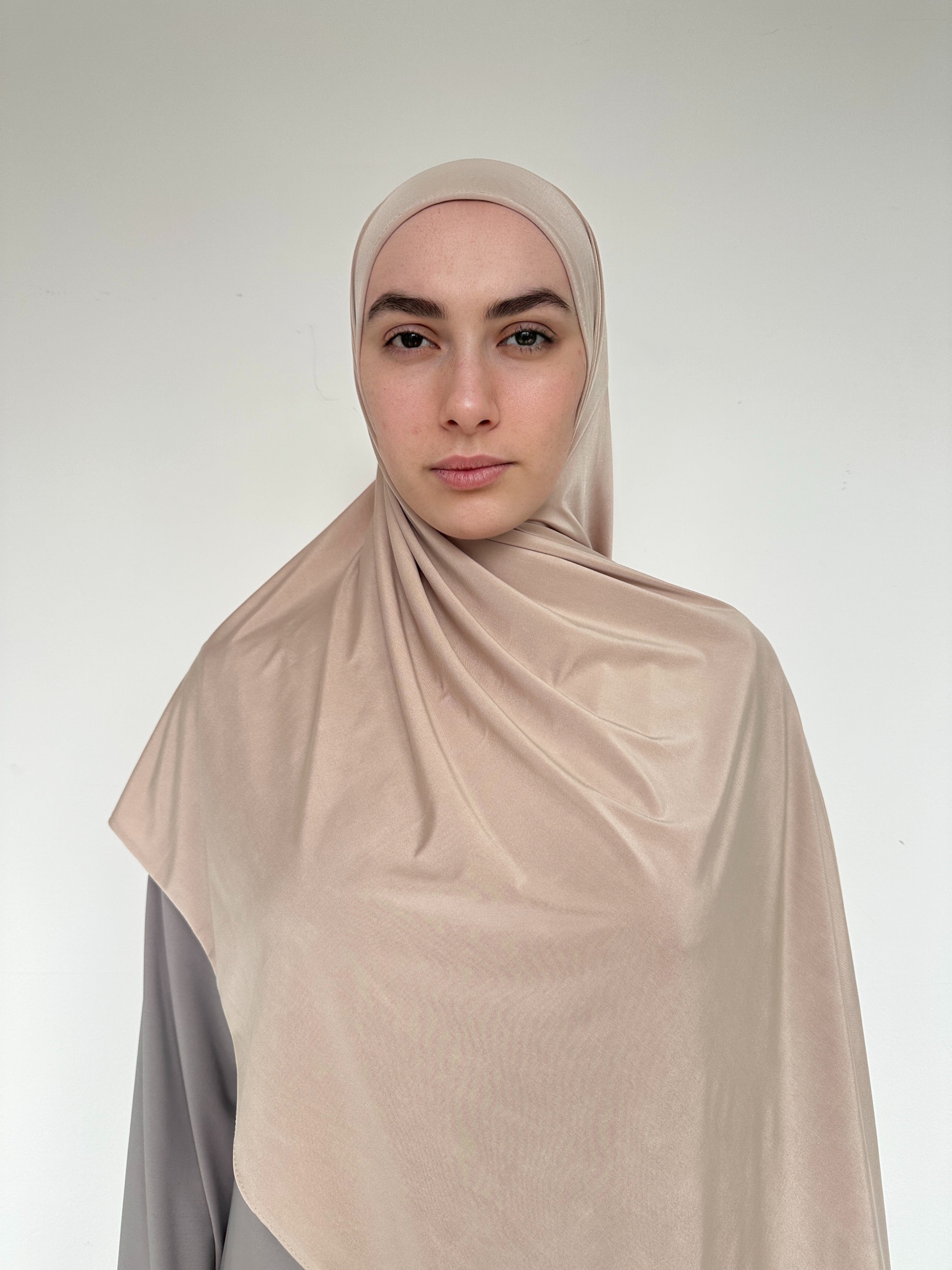 Hijab fluide beige sable, retombé élégant et tissu respirant.
