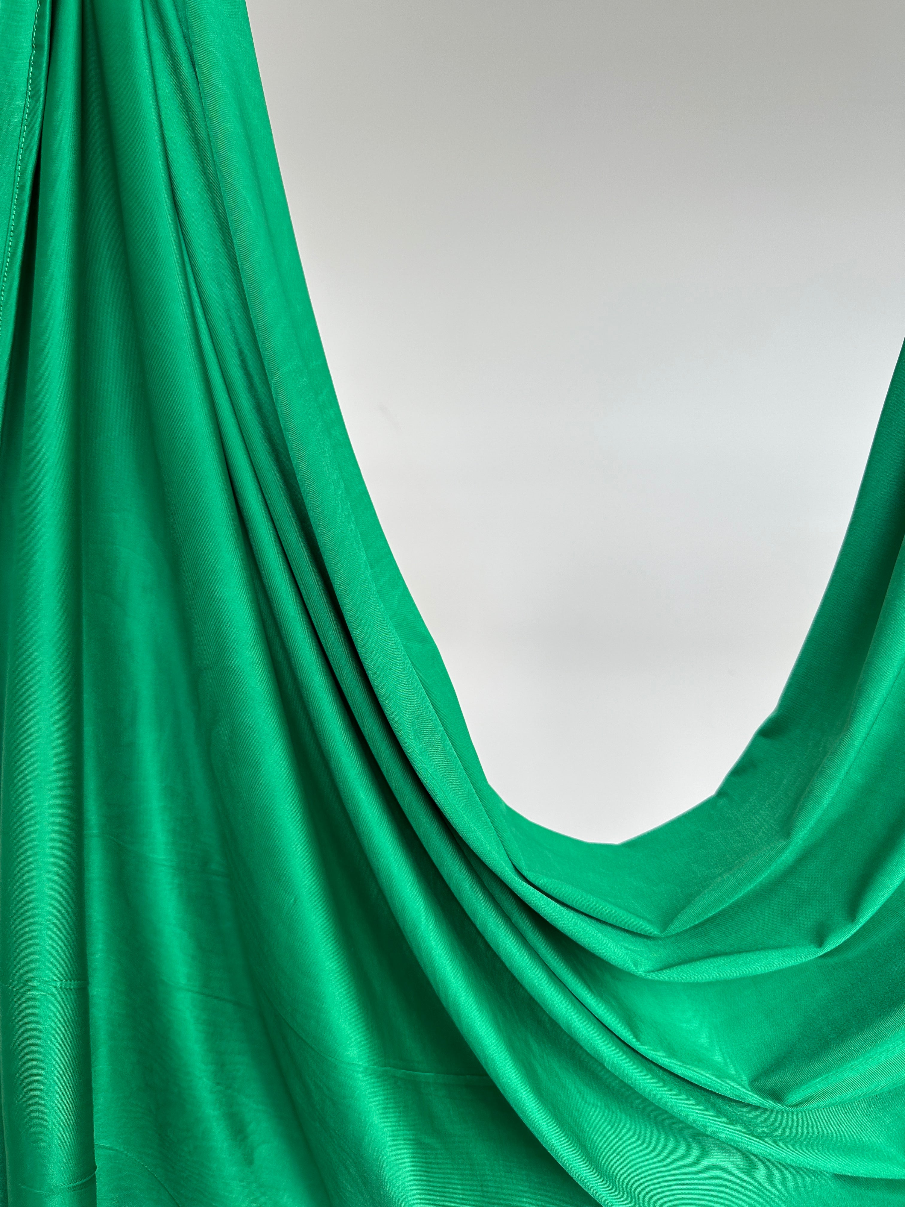 Détail de la texture satinée du hijab Jersey Liquid vert vif.